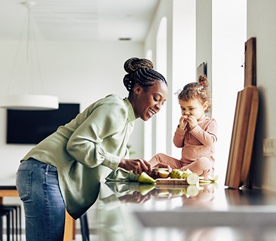 Mother and daughter eating snack in kitchen